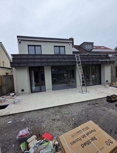 Two-storey rear extension with dark zinc cladding canopy