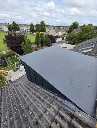 Rear view of extension with zinc canopy and large sliding doors